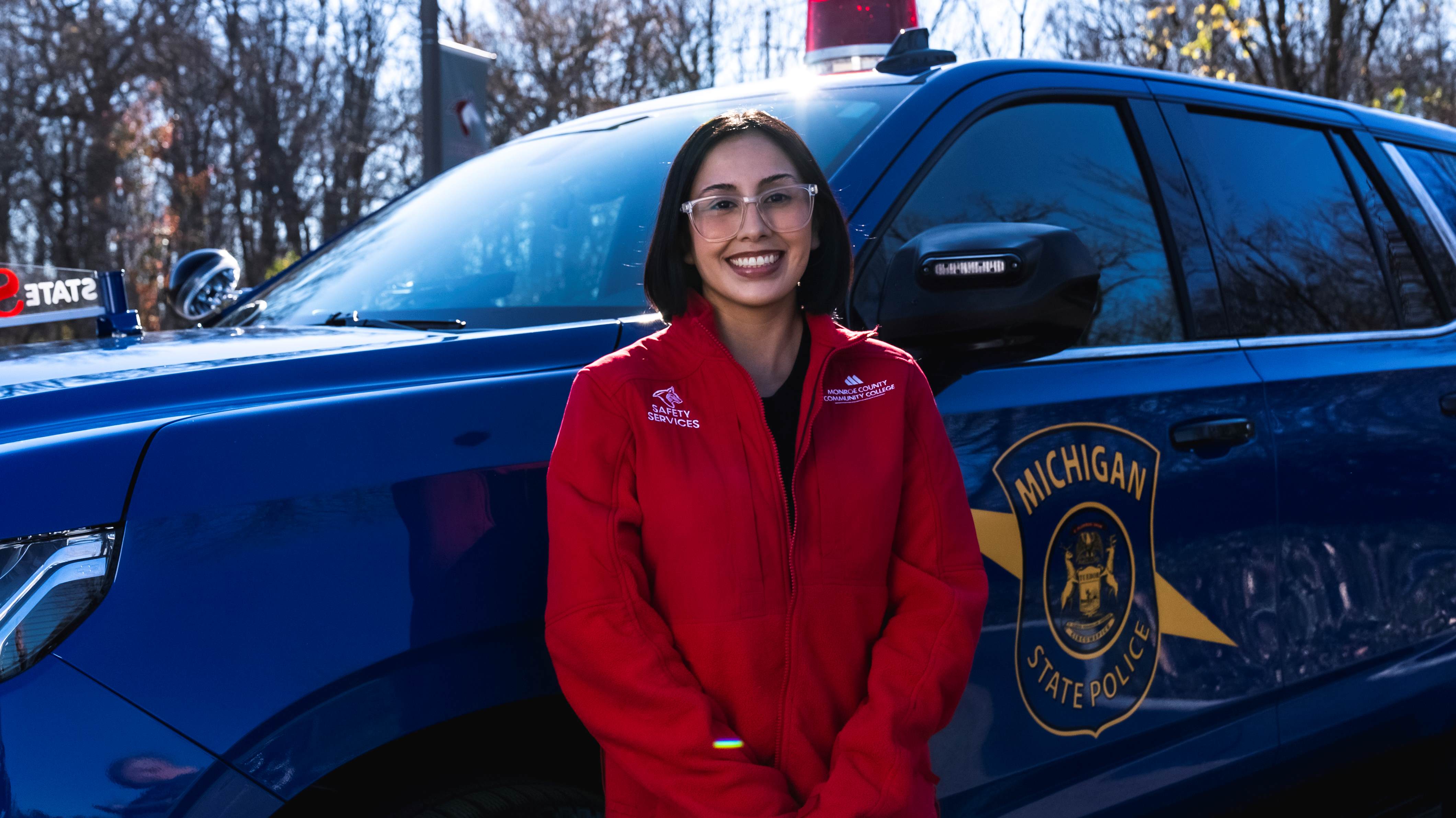Student in law enforcement in front of police car