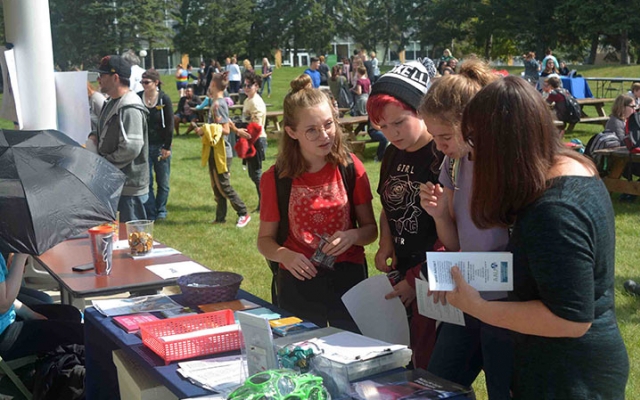 Students checking out club info at a table