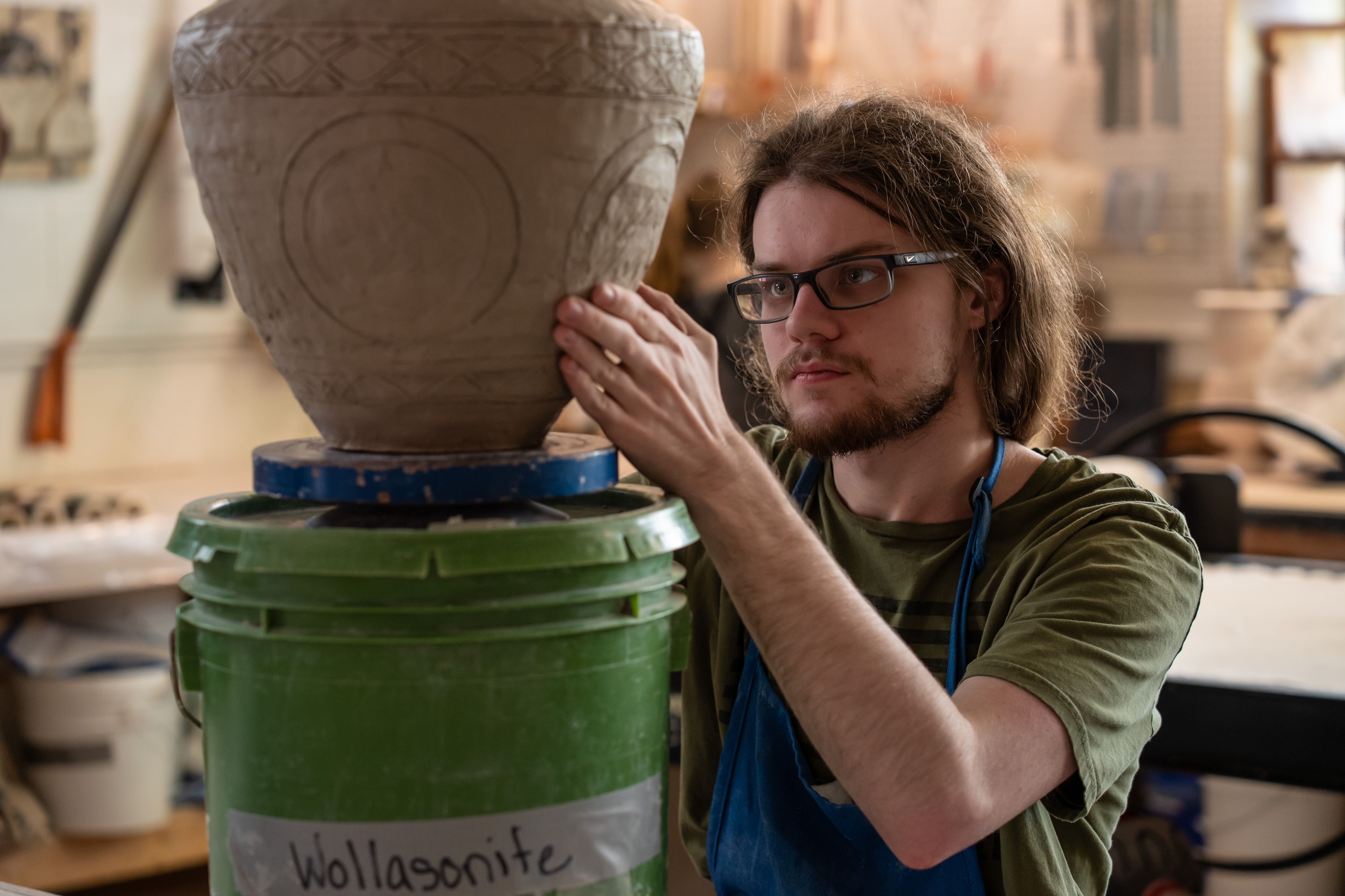 student working on pottery