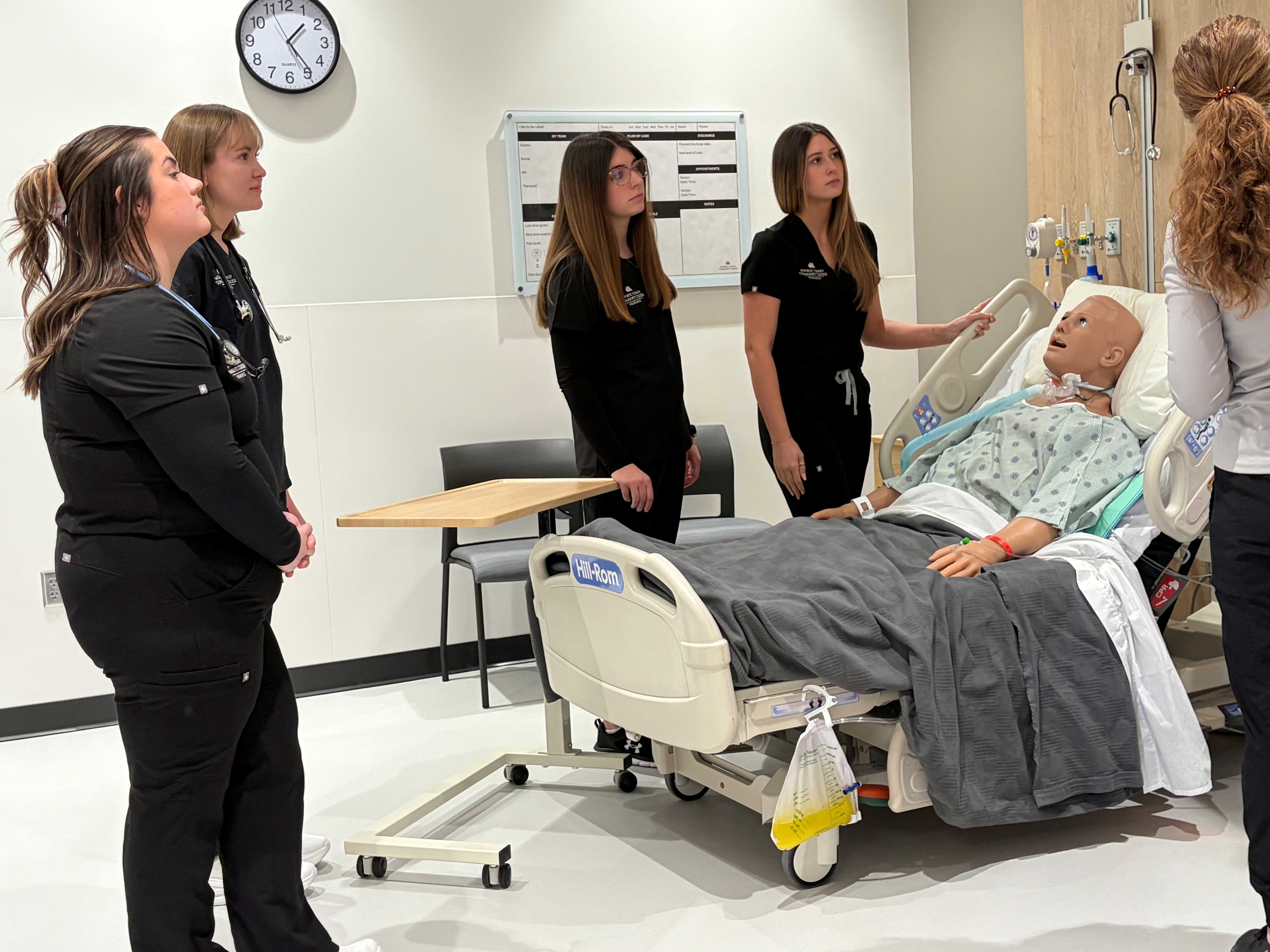 Students learning in simulation lab by working on a manikin.