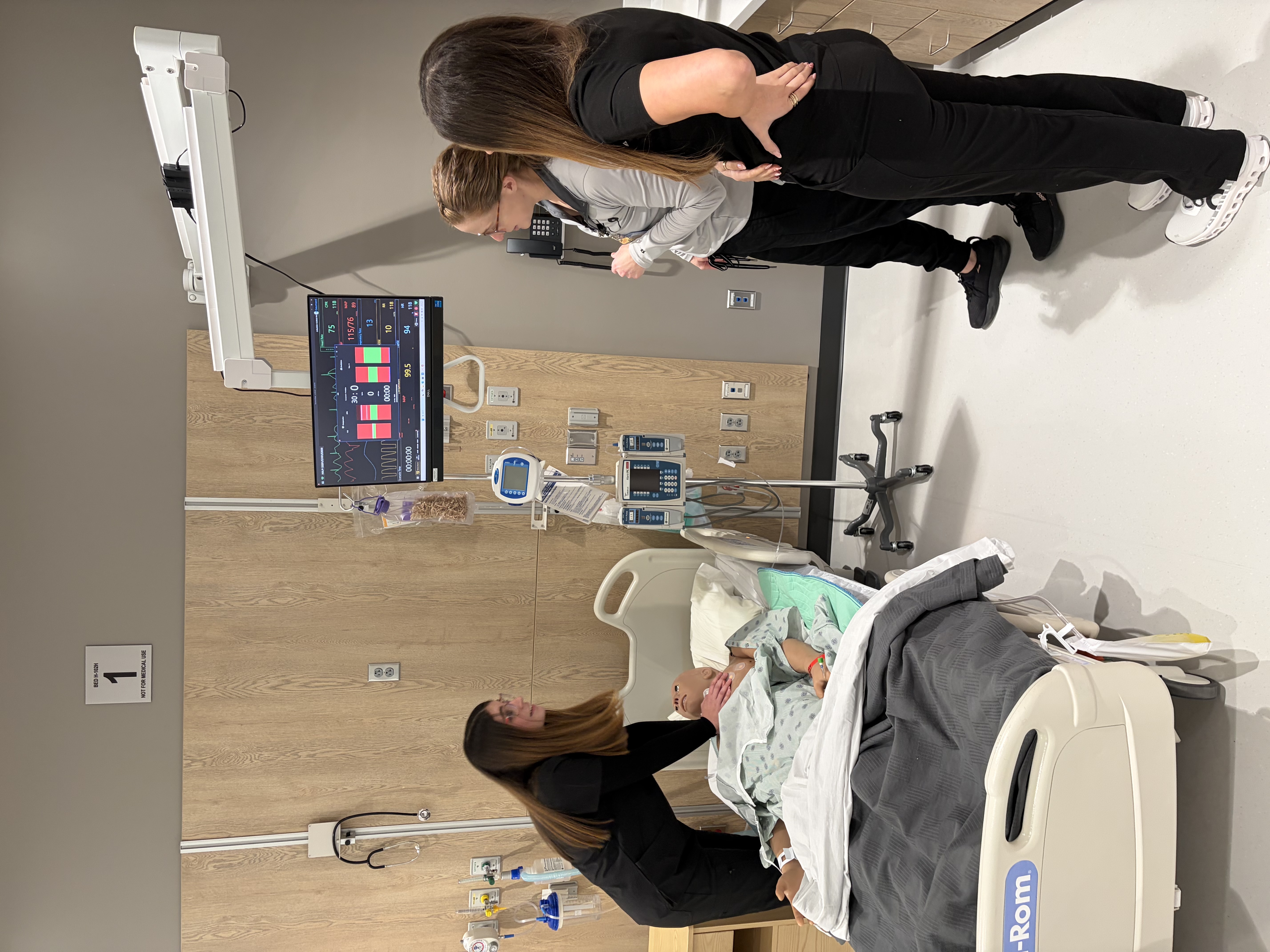 Students working on a manikin in simulation lab.