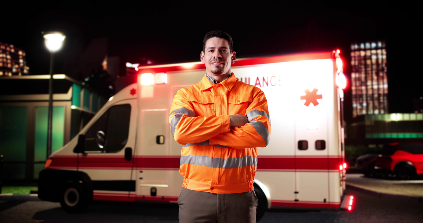 Paramedic in front of an ambulance at night