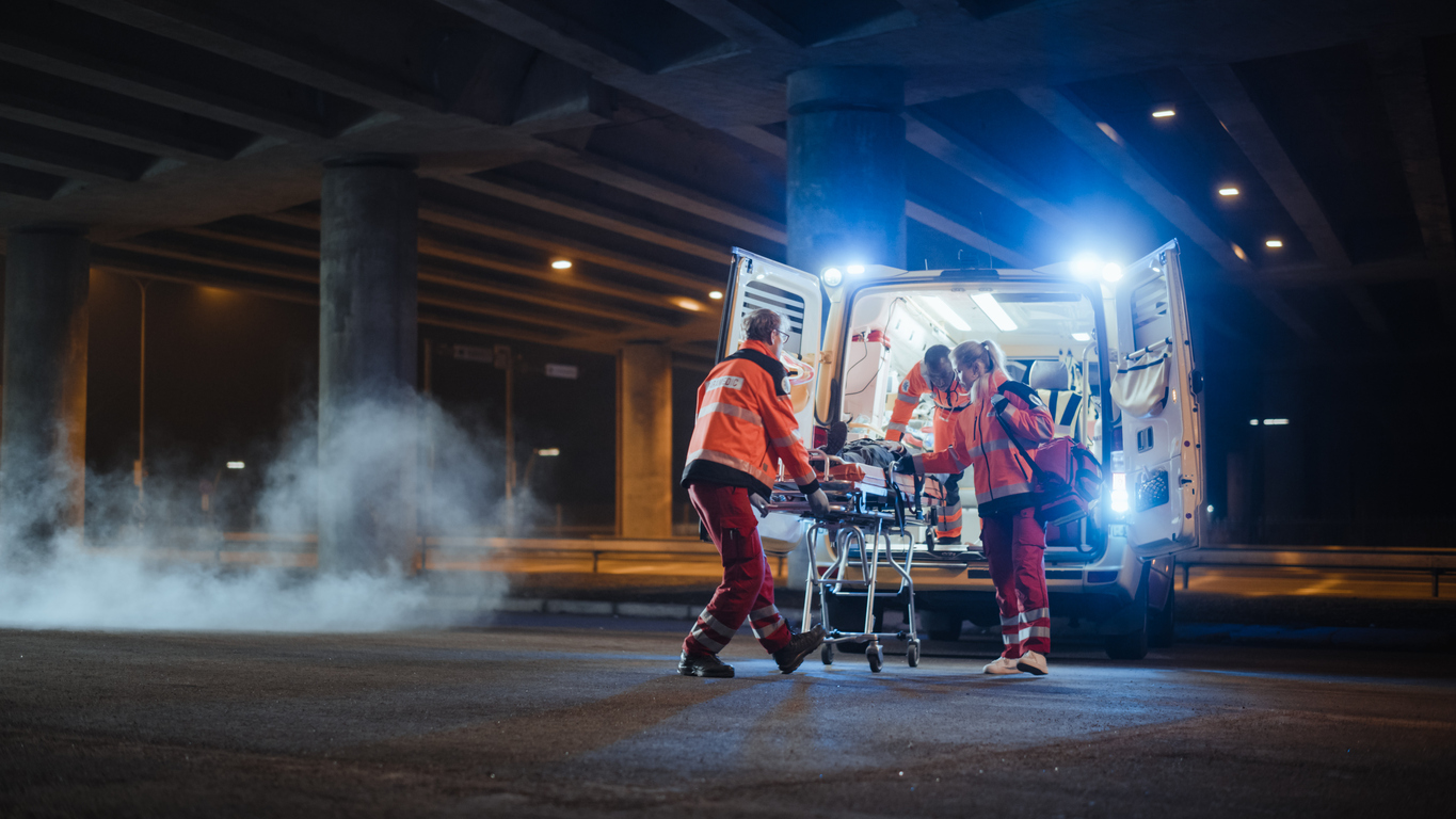 Paramedics loading a patient into an ambulance