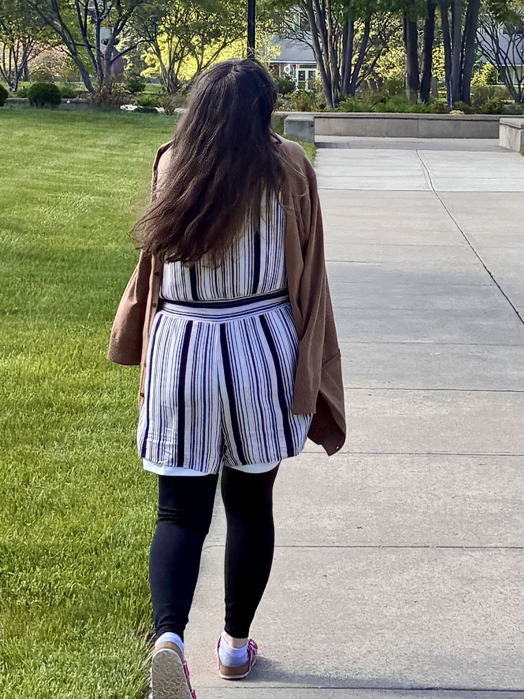 Student walking away clutching coat.