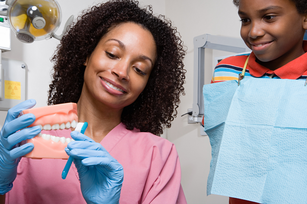 Woman brushing artificial teeth