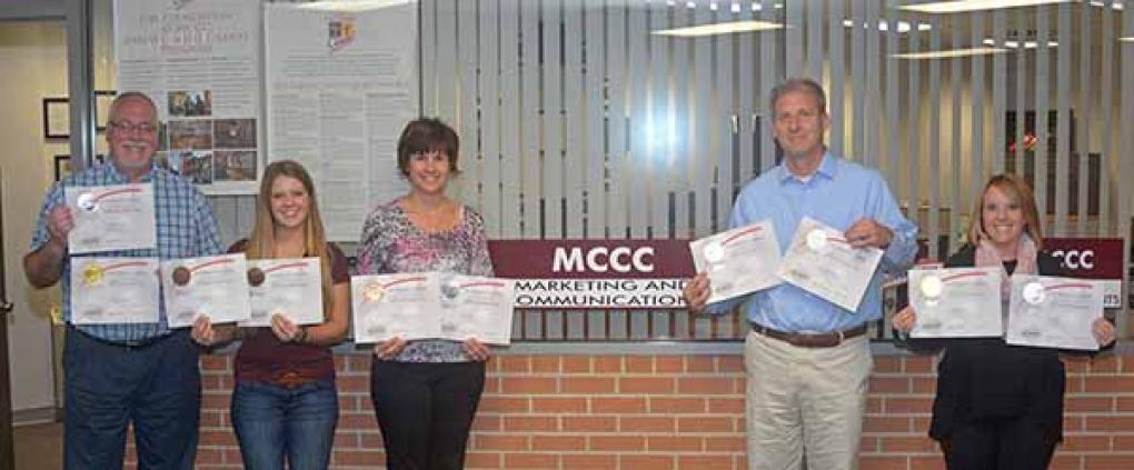 Employees in MCCC's Marketing and Communications Office and The Foundation at MCCC display the 10 marketing and public relations awards won by MCCC.