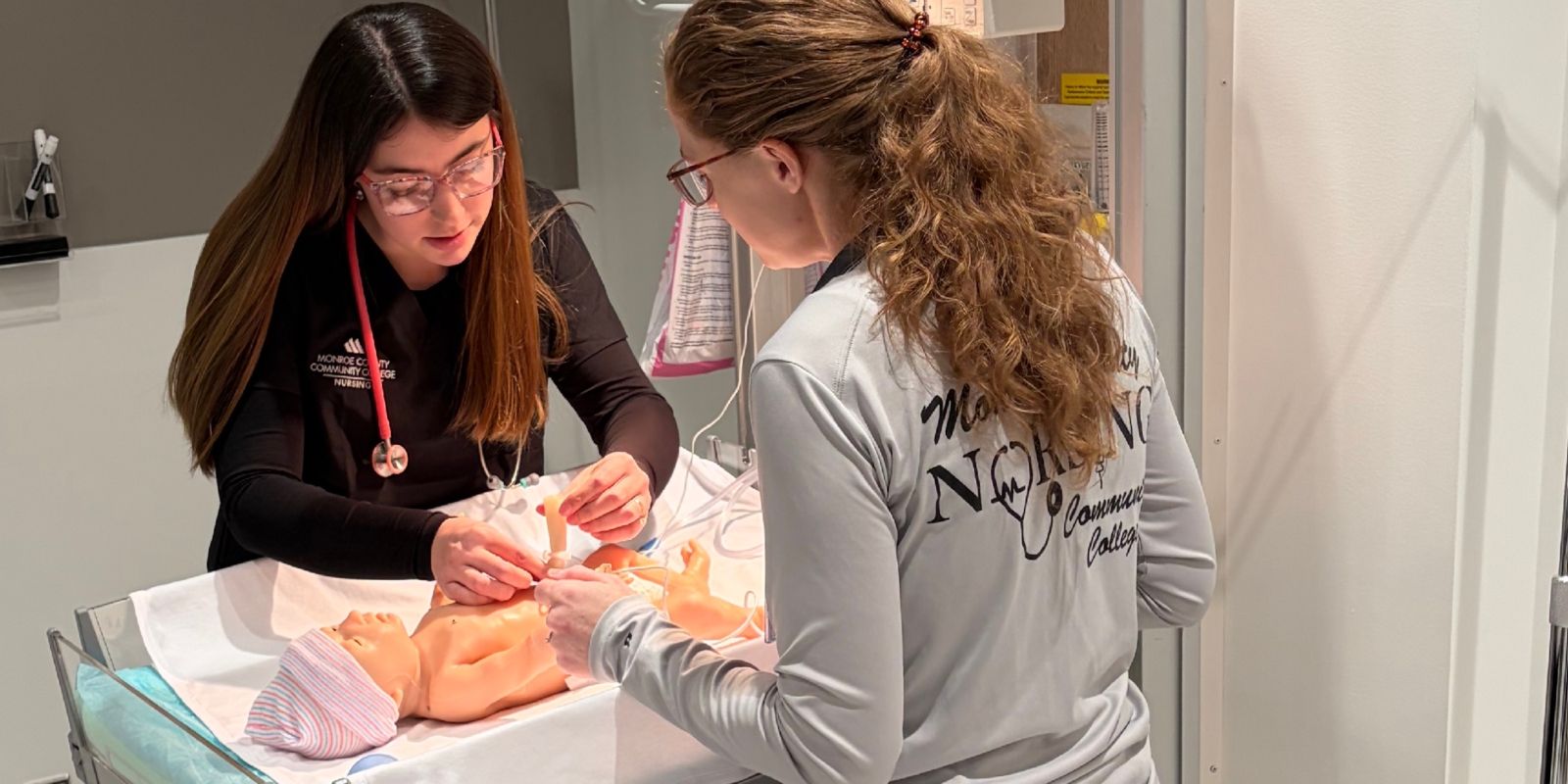 Nurse and instructor treating baby