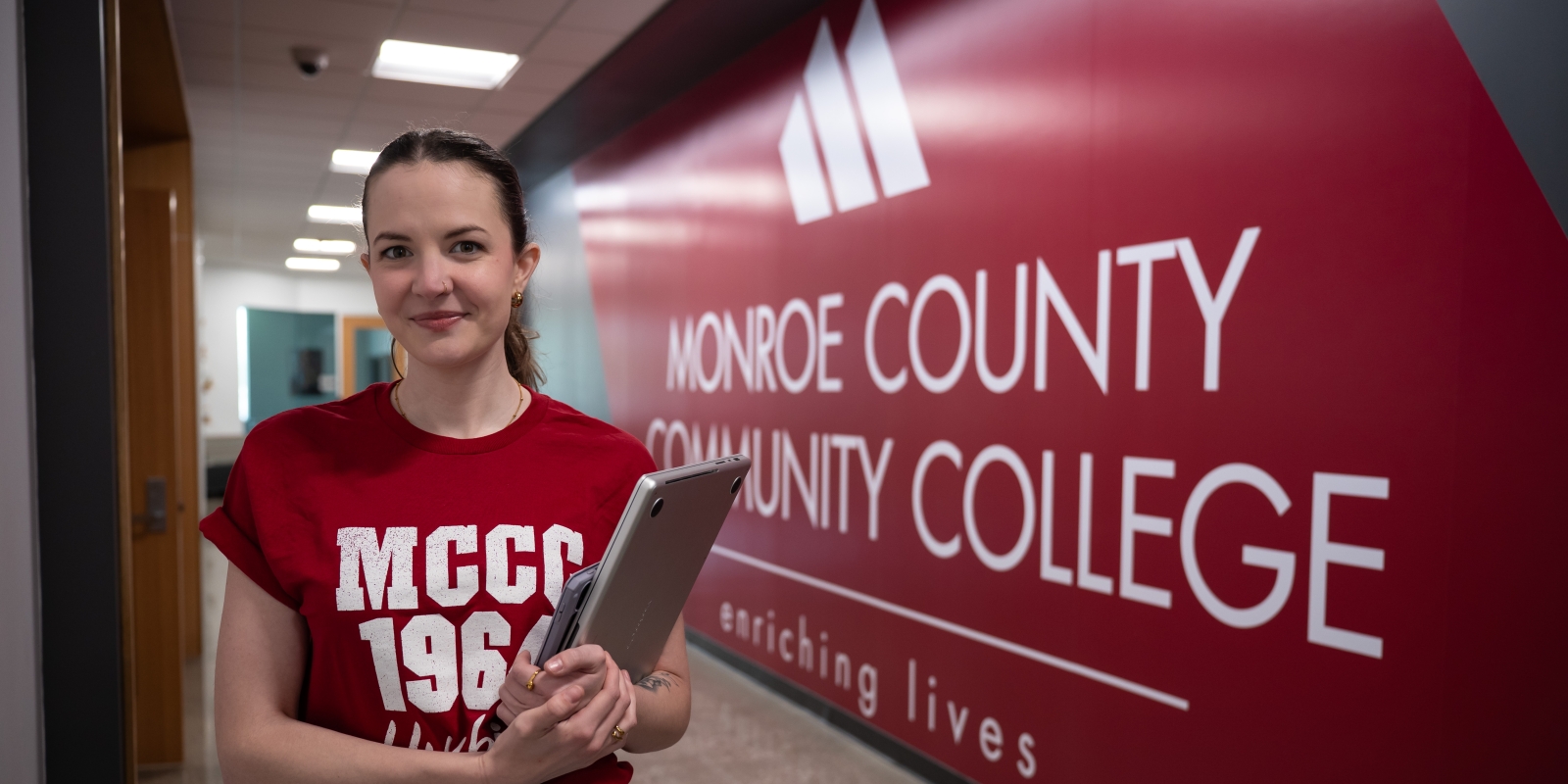 Female student in hallway with MCCC logo behind.