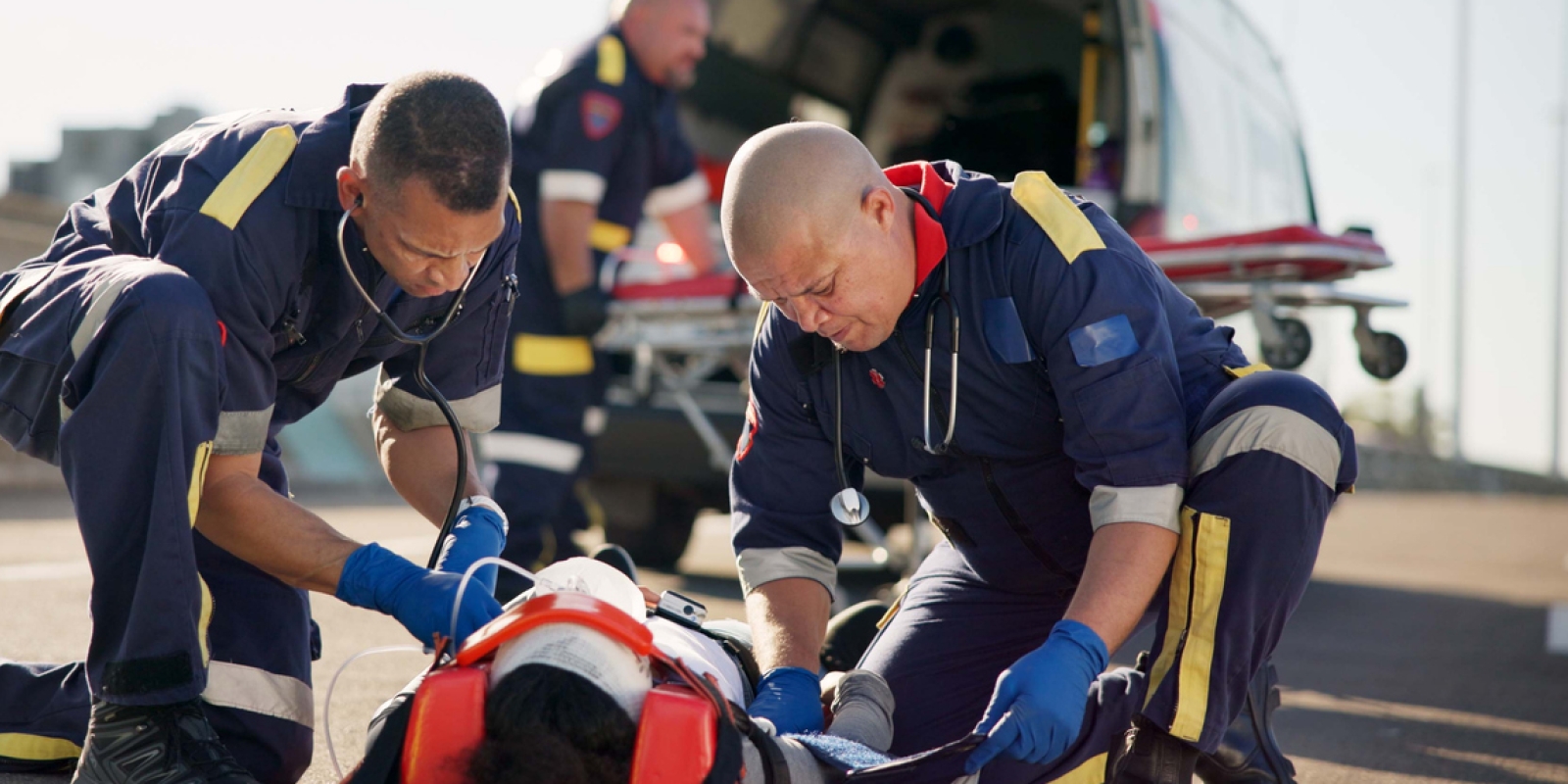 Paramedics asiisting a patient outside a helicopter.
