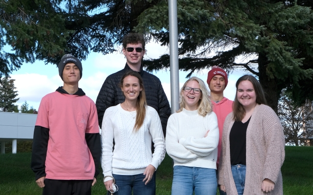 Group of students in front of flag pole